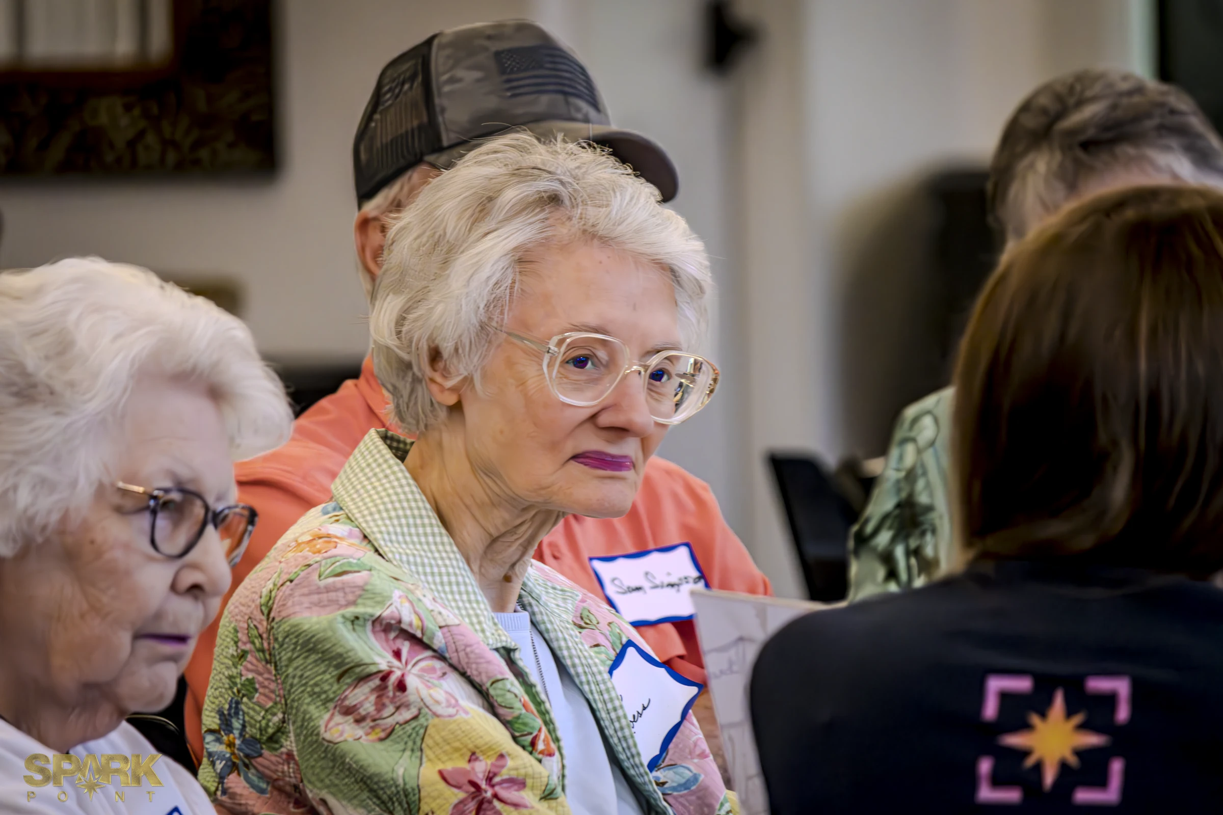 A Community Connectors participant listening during a small-group conversation.