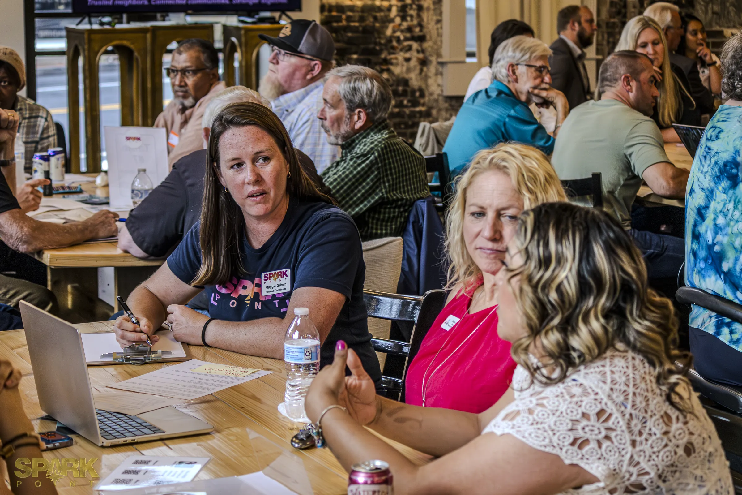 Community Connectors participants seated around tables during a facilitated listening session.